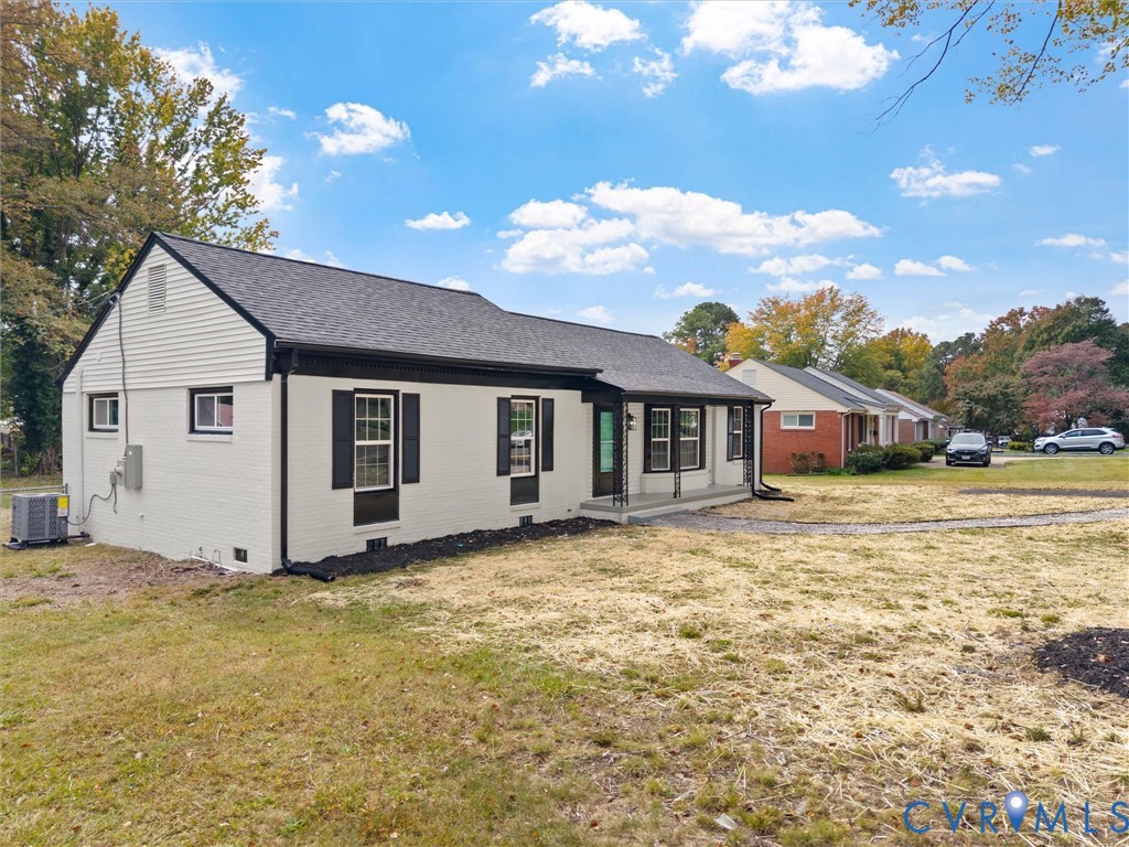 Painted brick exterior with horizontal siding accents, decorative window shutters, and an asphalt shingle roof