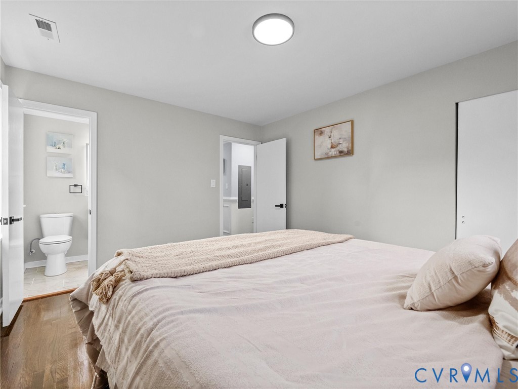 Neutral-toned interior featuring wood-finish flooring, a flush-mount ceiling light fixture, and a sliding-door closet