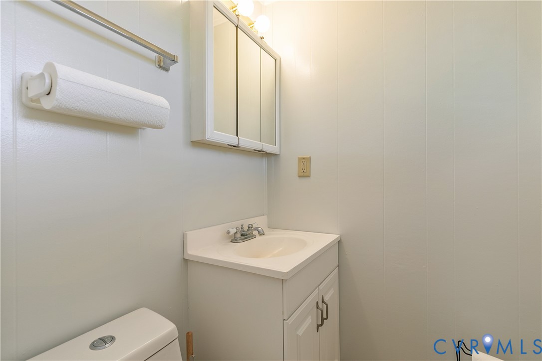 Wall-mounted vanity cabinet with an integrated sink, dual-door mirrored medicine cabinet, and brushed metal faucet hardware