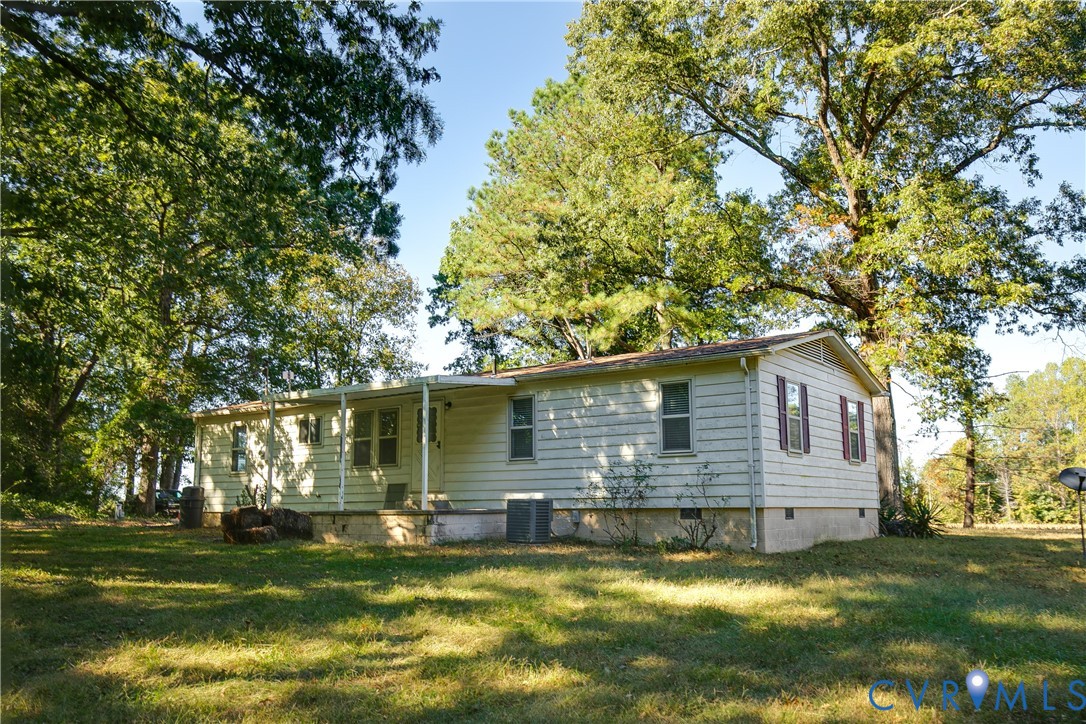 Exterior siding, covered porch, and mature trees situated on a spacious lot