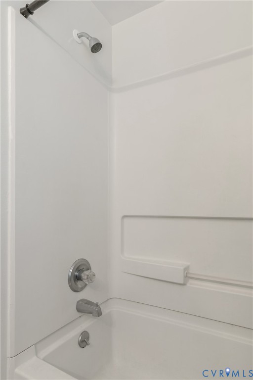 Bathtub and shower surround with a integrated soap ledge, chrome finish plumbing fixtures, and a clear acrylic handle