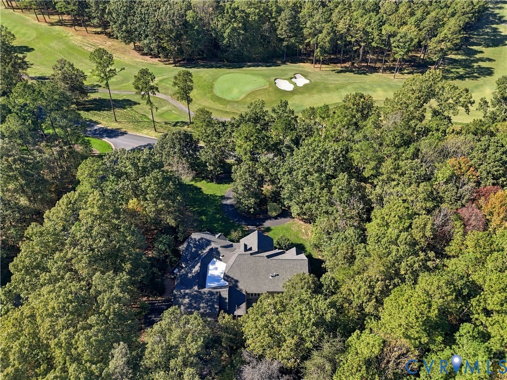 Aerial perspective featuring a multi-gabled roofline, private paved driveway, and established woodland setting bordering a golf course