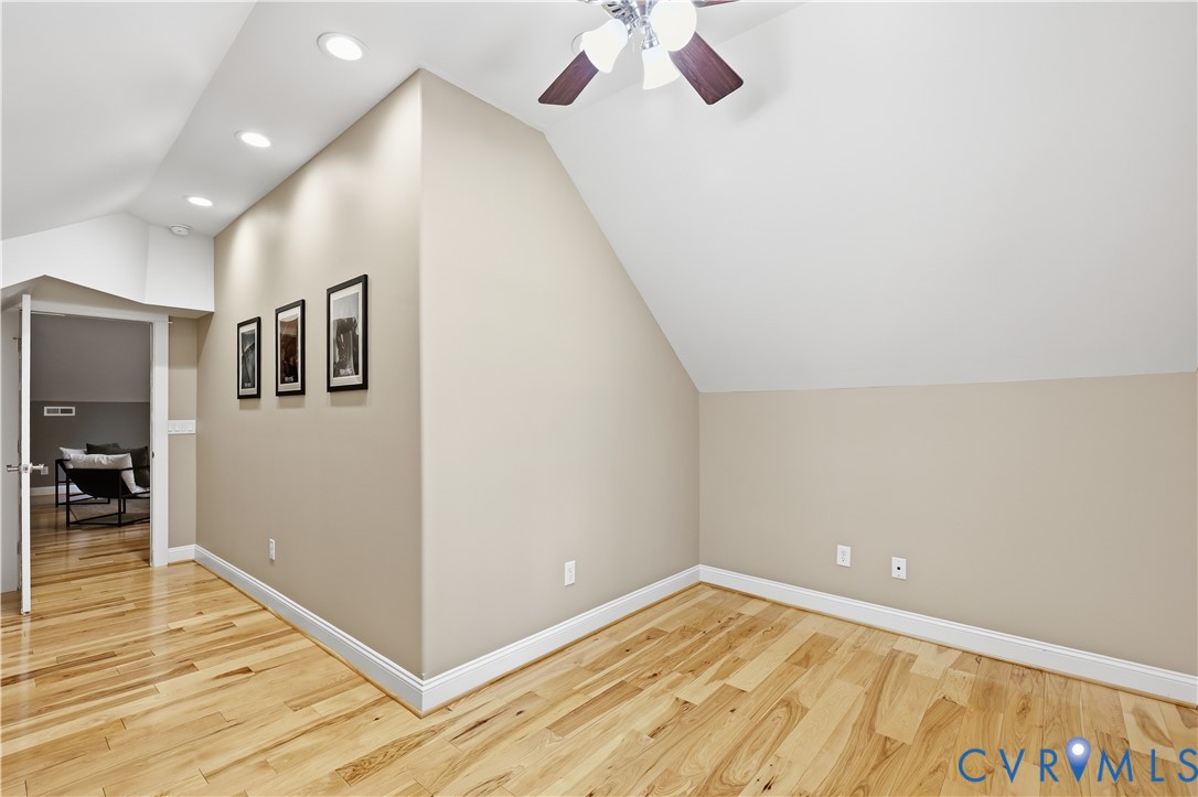 Vaulted ceilings featuring recessed lighting, wood-finish flooring, and a ceiling fan with integrated lighting