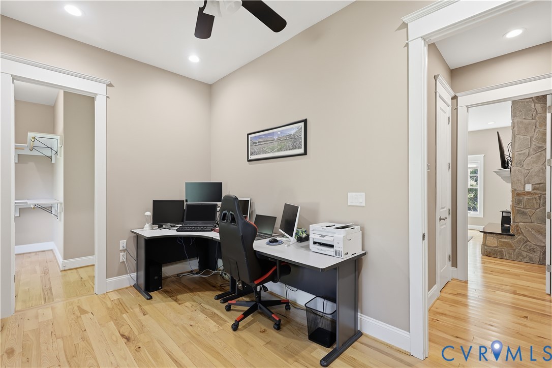 Wood-finish flooring, recessed lighting, ceiling fan, and multi-panel interior doors