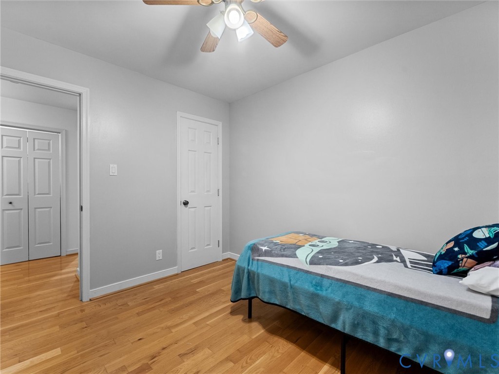 Interior space featuring wood-finish flooring, a ceiling fan with integrated lighting, and six-panel interior doors