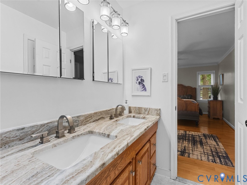 Dual-sink vanity with stone countertop, two recessed medicine cabinets, and bridge-style metal faucets