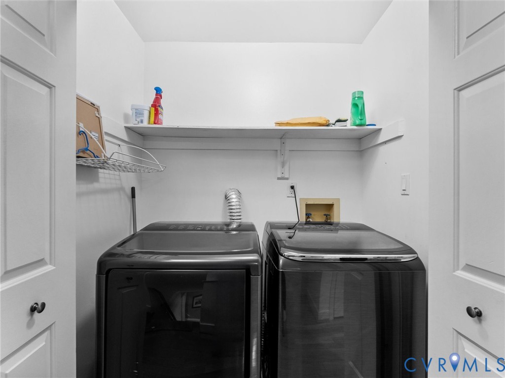 Laundry closet featuring double-panel doors, overhead shelving, and built-in utility hookups