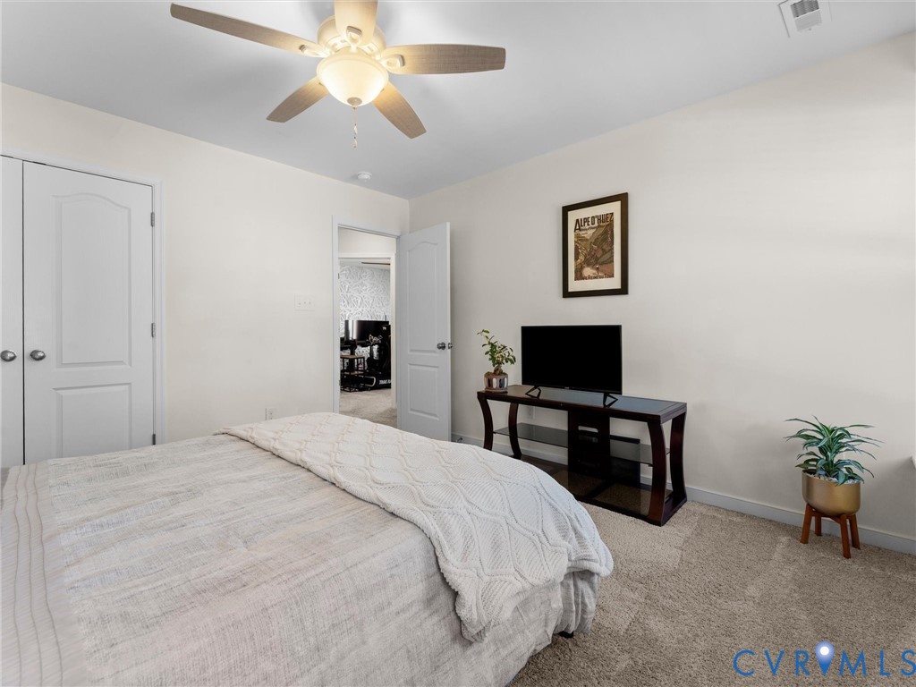Neutral-toned interior featuring wall-to-wall carpeting, a ceiling fan with integrated lighting, and two-panel interior doors