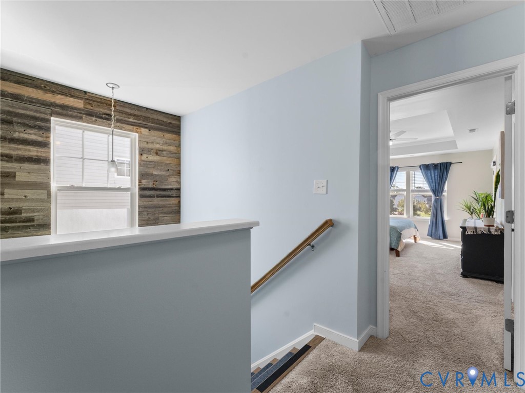 Wall featuring horizontal wood-plank cladding, single-hung window, pendant lighting, and a wooden handrail with metal supports