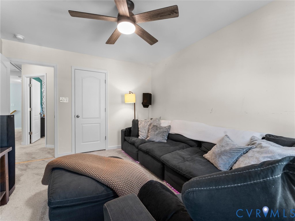 Interior space featuring wall-to-wall carpeting, an arched-panel interior door, and a central ceiling fan with integrated lighting