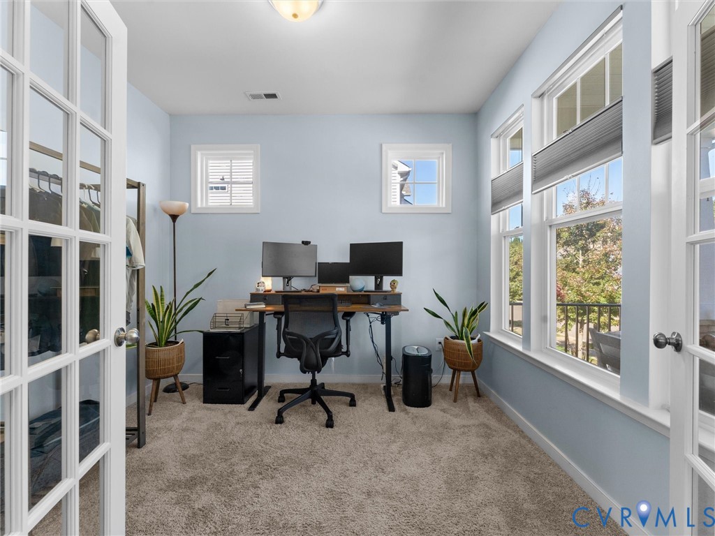 French doors with glass panes, plush carpeting, multi-pane windows with integrated blinds, and ceiling-mounted lighting