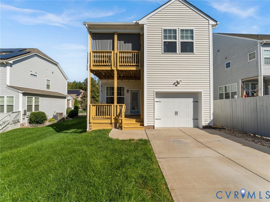Rear exterior with attached garage, deck and fenced yard