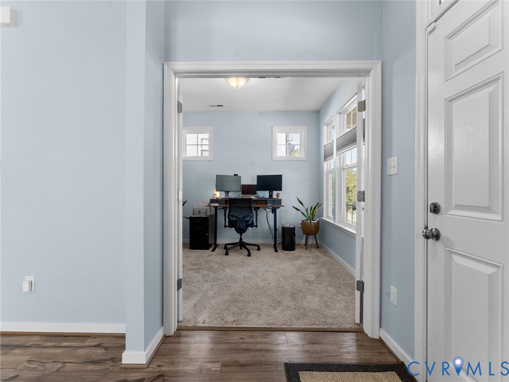 Double French door entry, wood-finish flooring, neutral carpet, flush-mount ceiling lighting, and multiple windows
