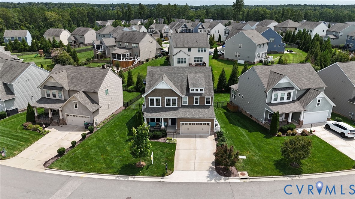 Two-story residential property featuring a masonry and fiber-cement siding facade, a front-facing attached two-car garage, an asphalt shingle roof, and a paved concrete driveway