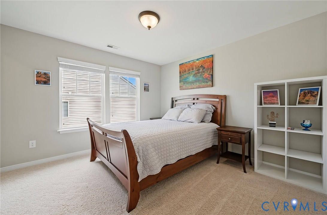 Neutral-toned walls, plush wall-to-wall carpeting, dual-pane windows, and a flush-mount overhead light fixture