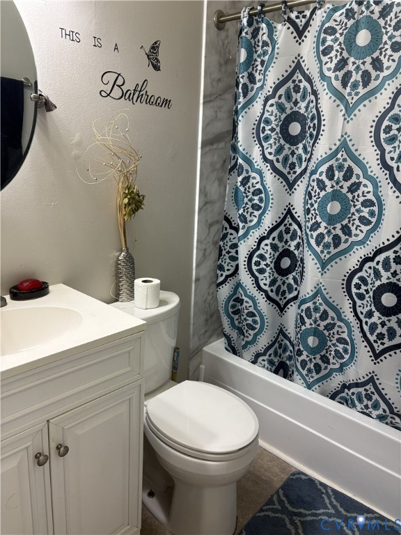 Bathroom featuring a white vanity cabinet with an integrated basin, a standard-height toilet, and a tub-shower combination with surround tile