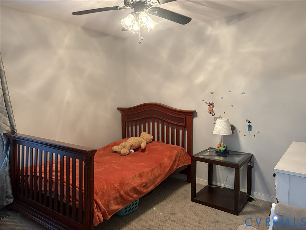 Bedroom featuring neutral wall paint, carpeted flooring, and a ceiling fan with integrated lighting