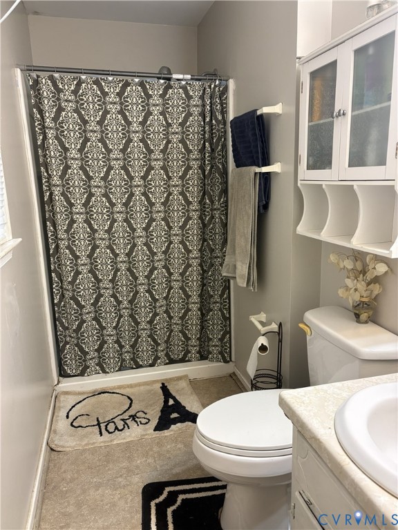 Full bathroom featuring a shower-tub combination, white vanity with an integrated basin, and wall-mounted cabinetry with glass-paneled doors