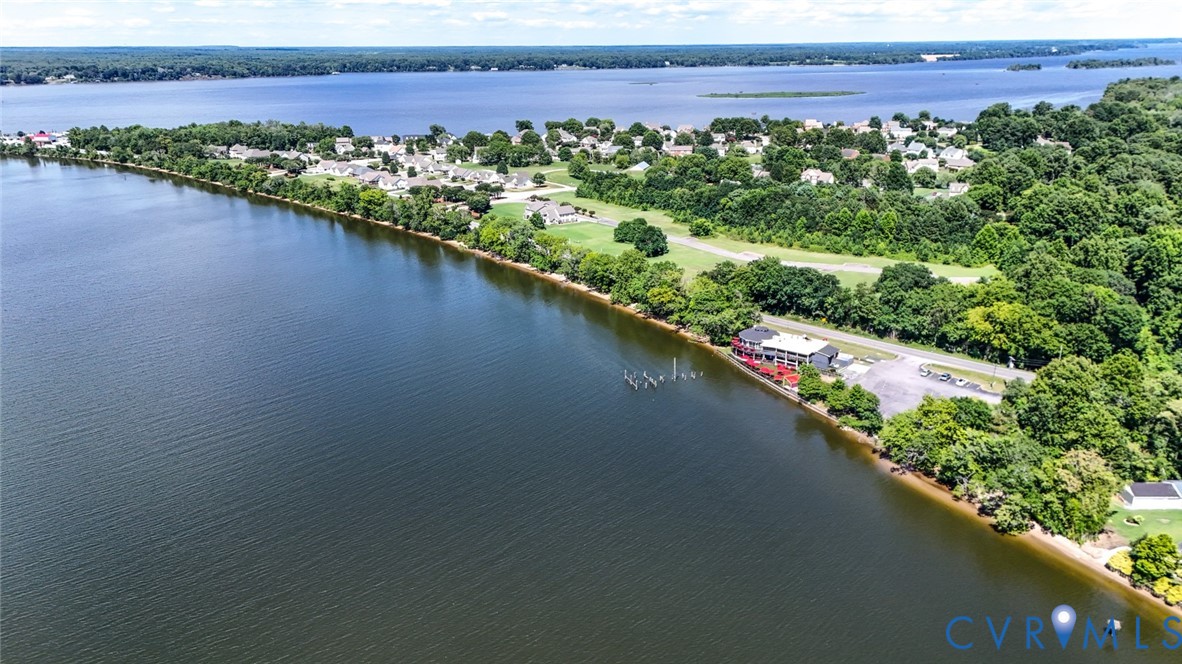 Waterfront property featuring extensive shoreline, private dock, and mature trees