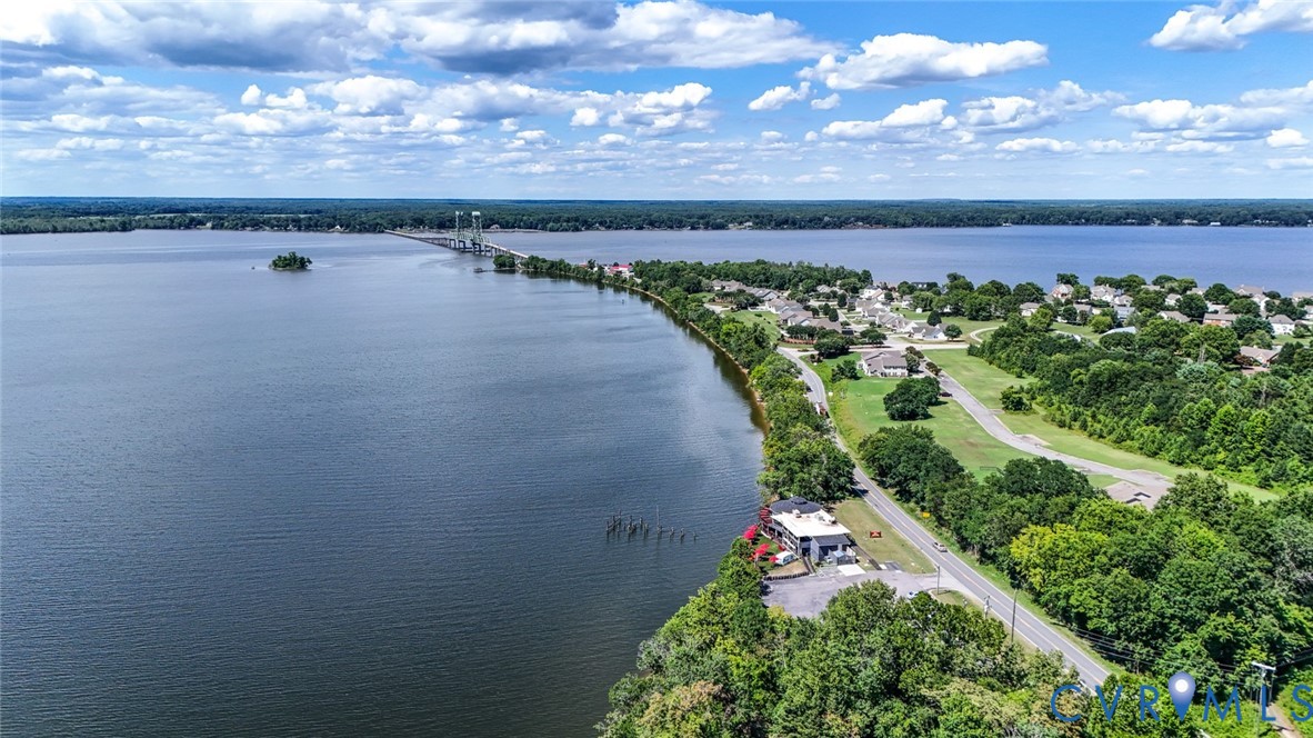 Aerial perspective of waterfront property featuring extensive shoreline frontage, direct water access, and surrounding mature woodland