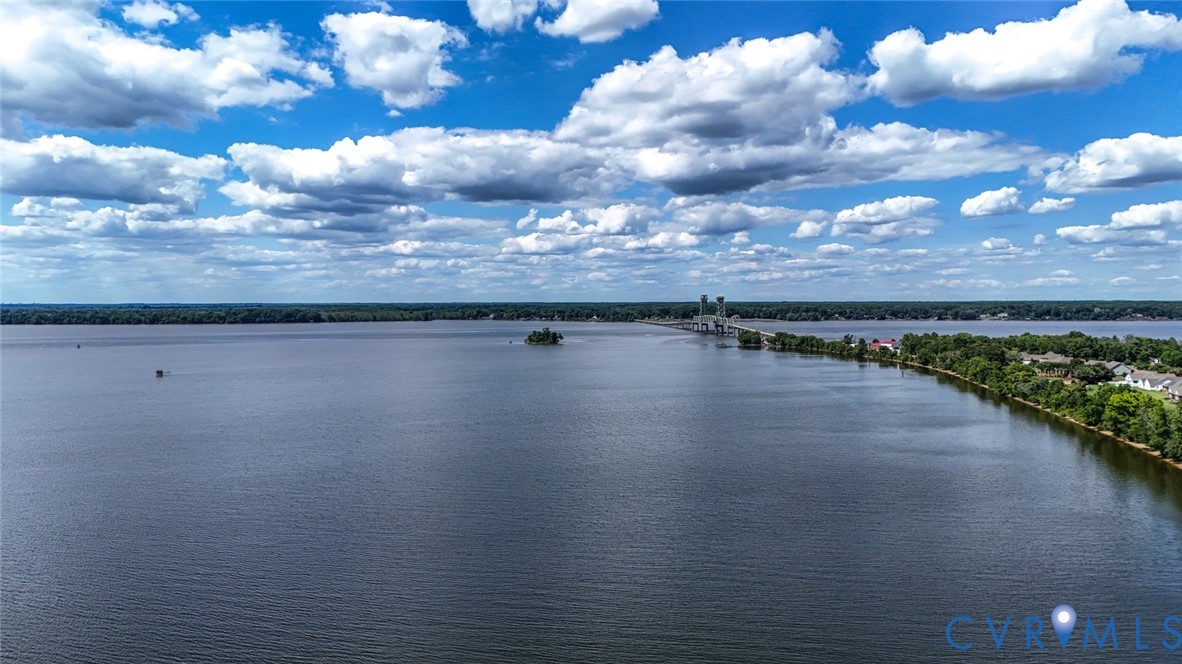 Expansive waterfront setting featuring direct shoreline access and dense, mature tree lines
