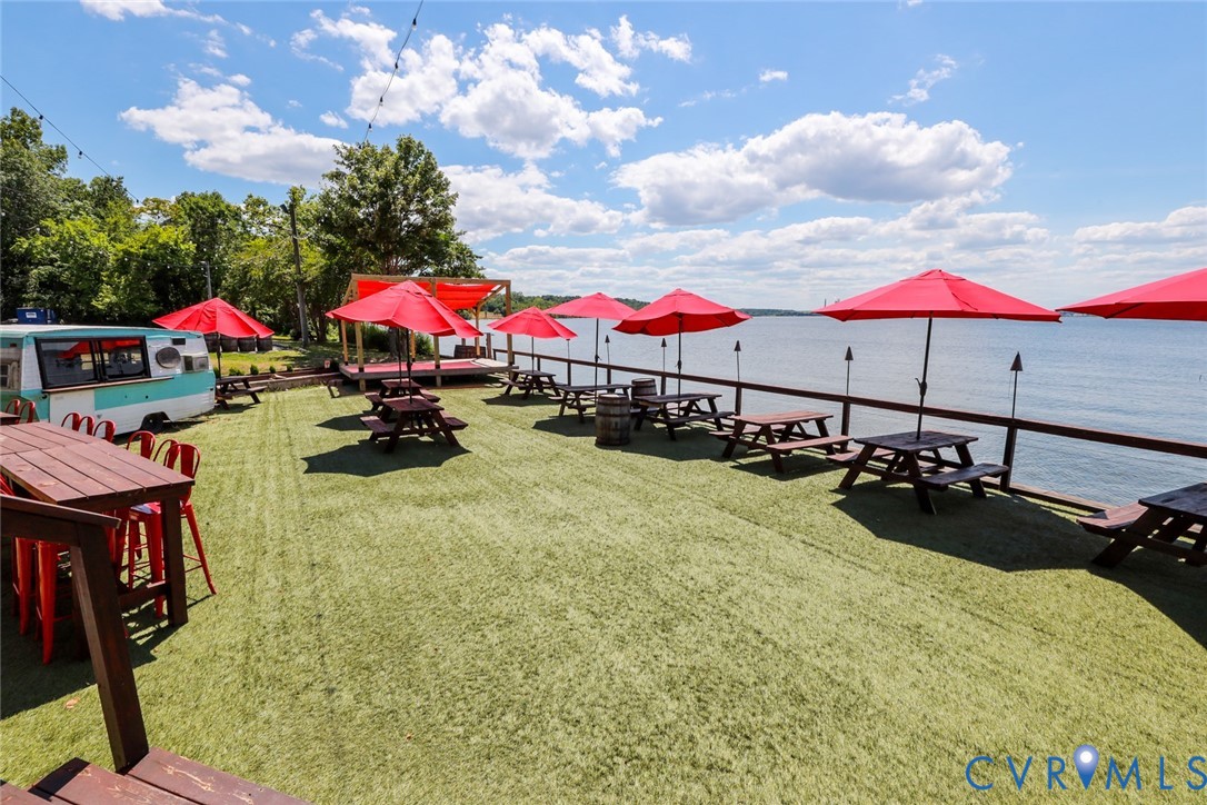 Waterfront outdoor space featuring artificial turf, a timber-framed platform, and a perimeter railing