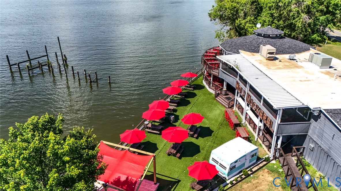 Waterfront property featuring a multi-level deck, direct bulkhead access, and an expansive lawn area