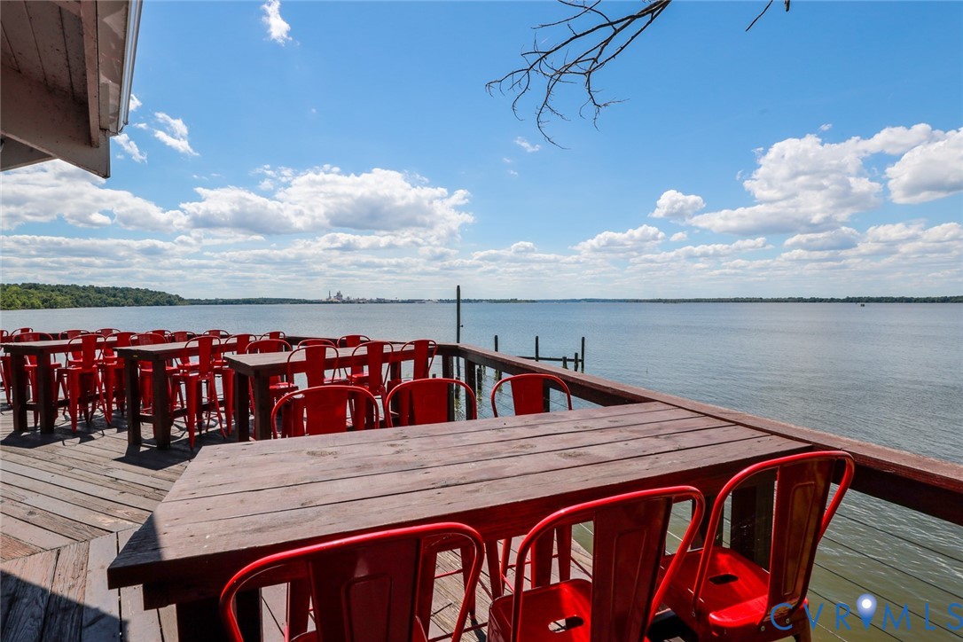 Waterfront deck featuring wood-plank flooring and a wooden railing