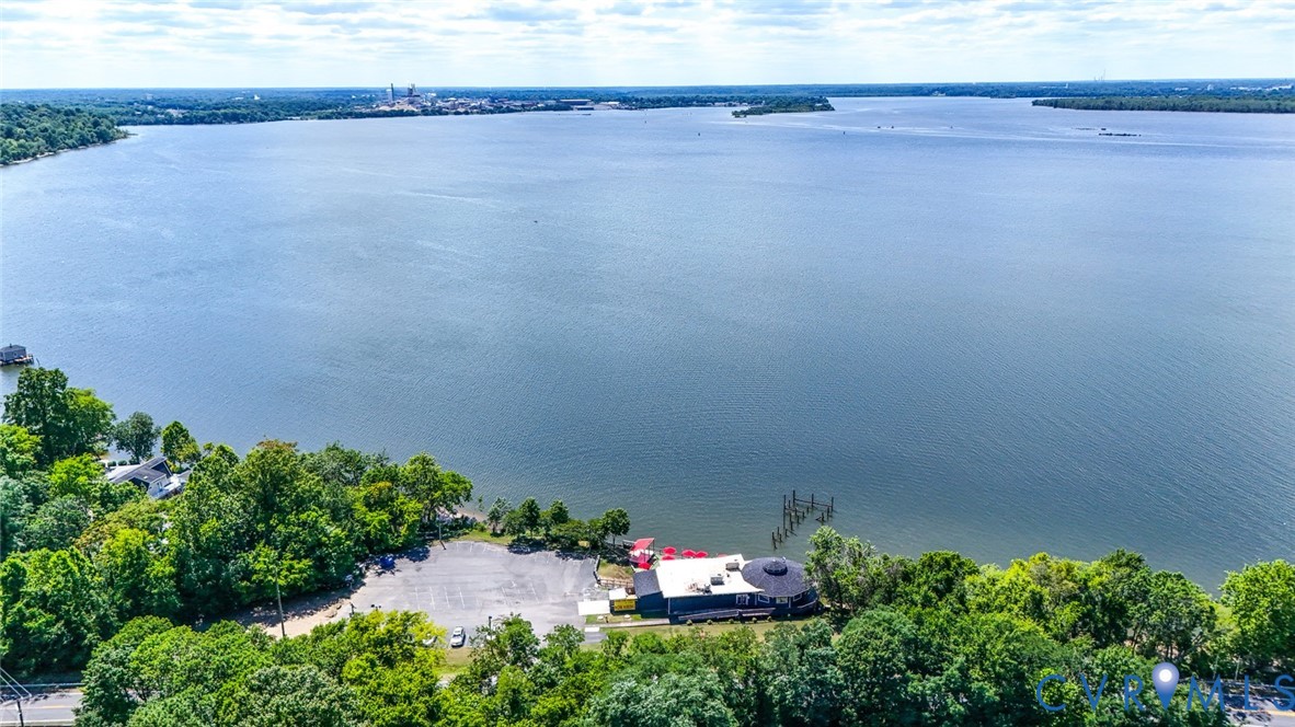 Waterfront property featuring an expansive shoreline, mature tree canopy, and direct open-water access
