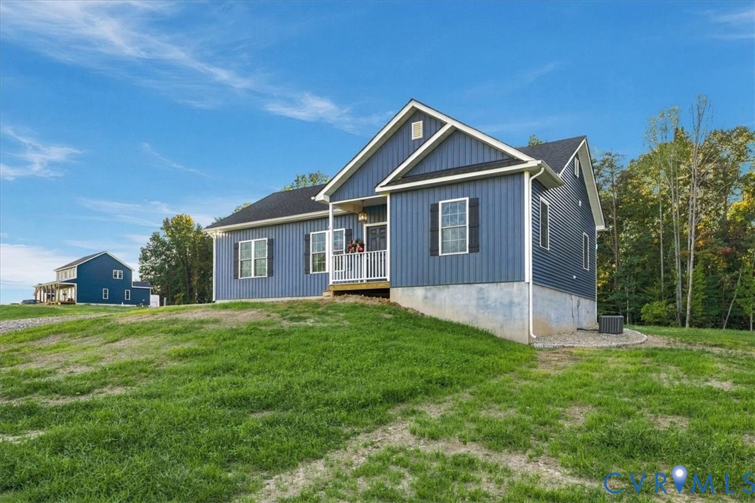 Single-story residence featuring vertical siding, a front porch with railing, decorative window shutters, and a concrete foundation