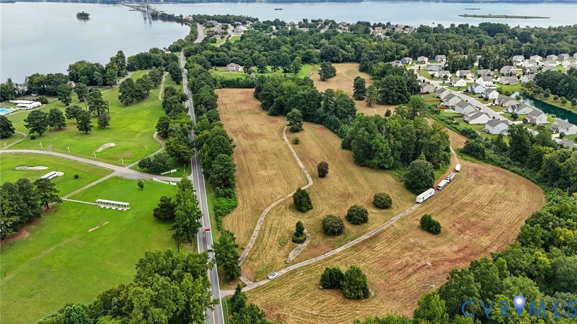 Expansive acreage featuring mature tree lines, established greenery, open terrain, and waterfront proximity
