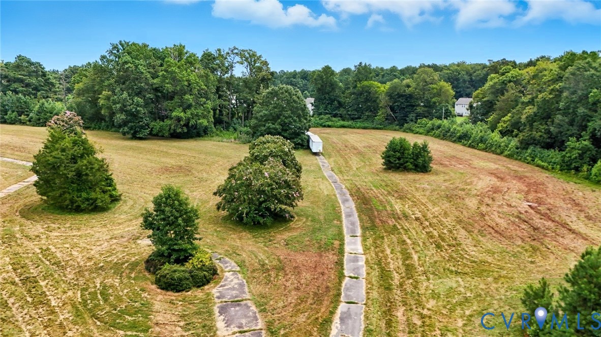 Expansive acreage featuring cleared pasture, paved driveway access, and mature tree buffers Expansive acreage featuring cleared pasture, paved driveway access, and mature tree buffers