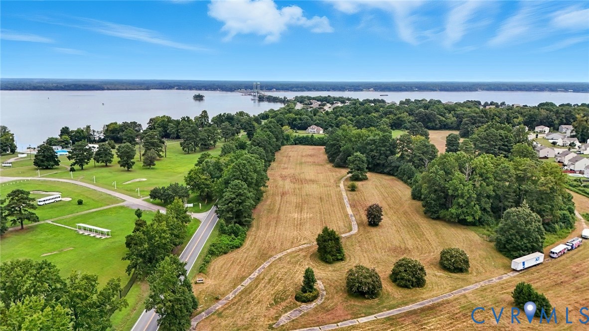 Expansive lot featuring mature trees, established landscaping, and direct water frontage