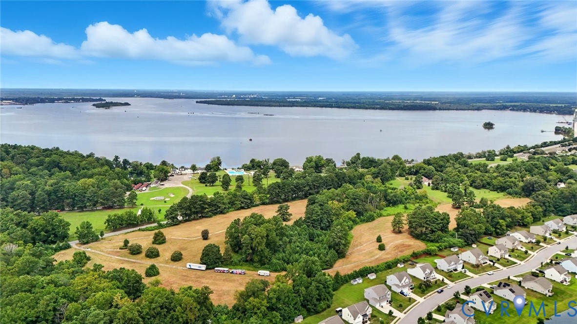 Aerial perspective featuring expansive waterfront acreage, mature tree canopy, and established neighborhood infrastructure Aerial perspective featuring expansive waterfront acreage, mature tree canopy, and established neighborhood infrastructure