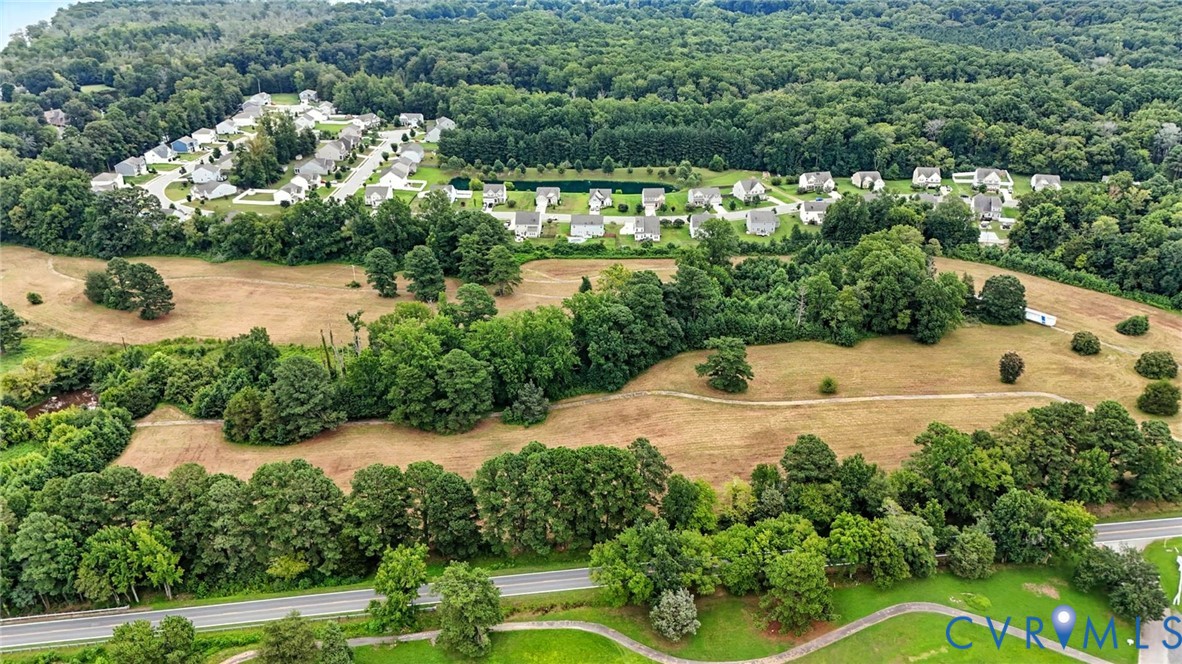 Aerial perspective of expansive acreage featuring mature hardwood tree stands, cleared open fields, and established perimeter vegetation Aerial perspective of expansive acreage featuring mature hardwood tree stands, cleared open fields, and established perimeter vegetation