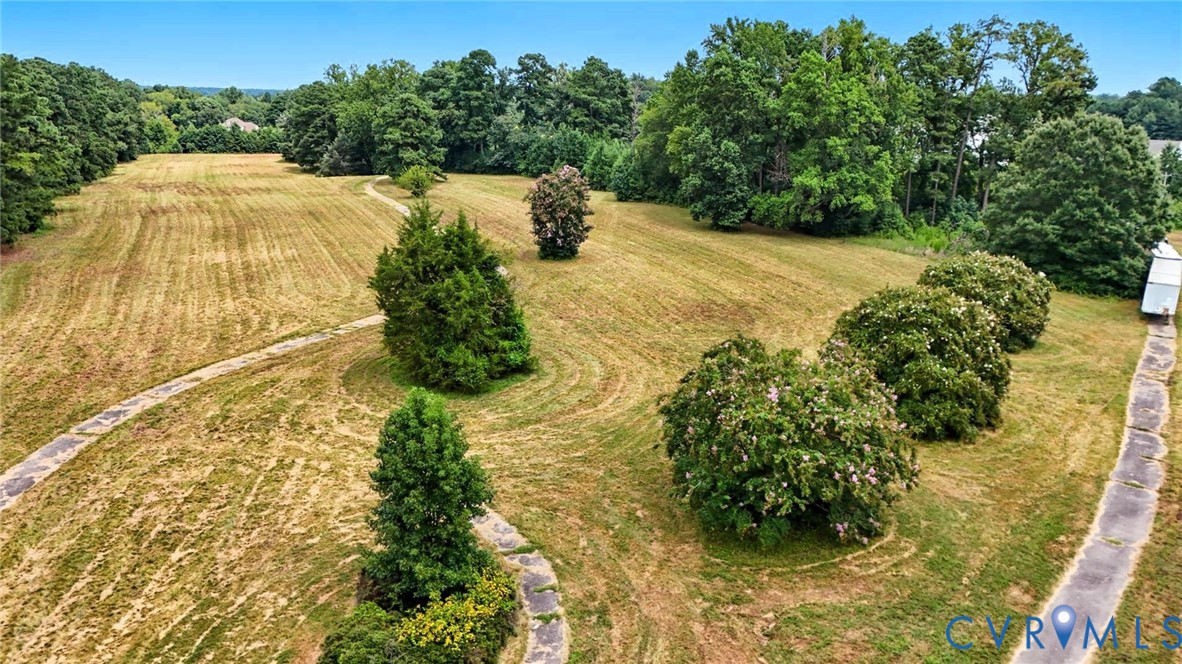 Expansive acreage featuring mature trees, sweeping grassy terrain, and winding concrete pathways Expansive acreage featuring mature trees, sweeping grassy terrain, and winding concrete pathways
