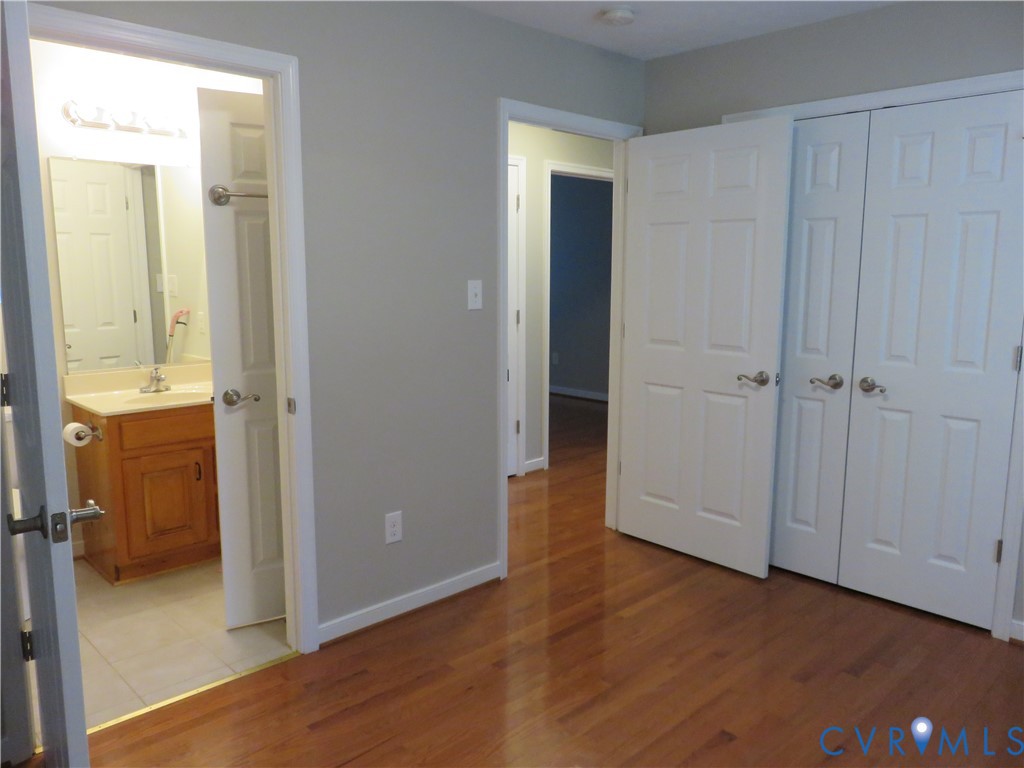 Wood-finish flooring, white six-panel interior doors, and dual-door closet storage