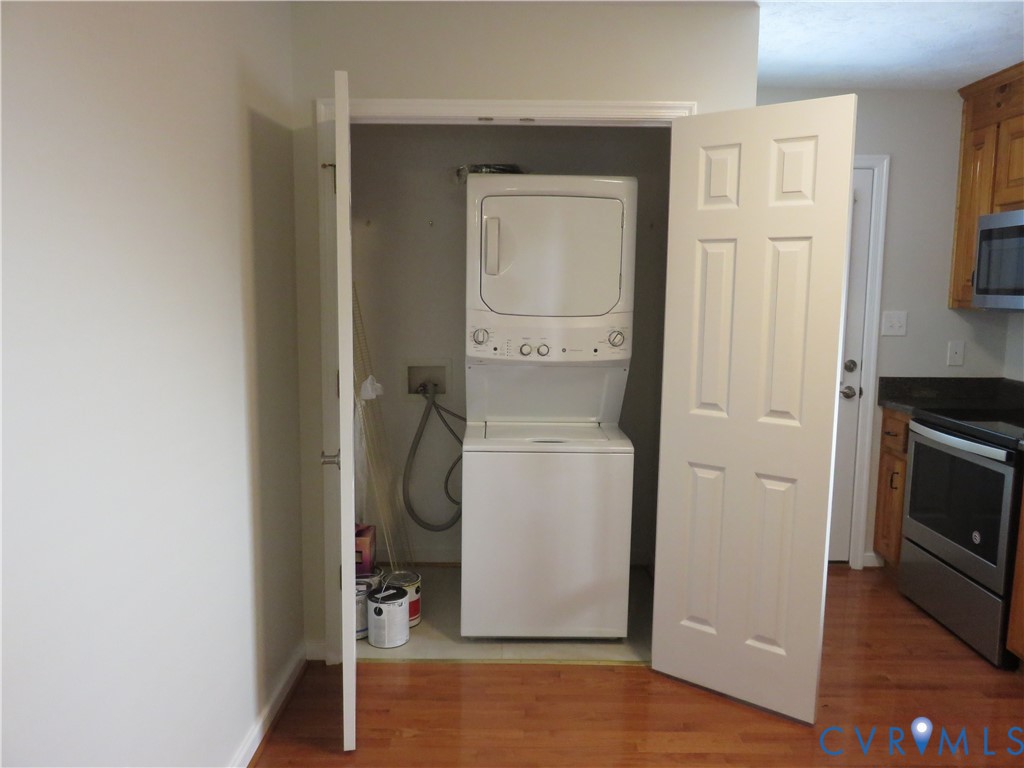 Laundry closet featuring a stackable washer and dryer unit and white six-panel bi-fold doors Laundry closet featuring a stackable washer and dryer unit and white six-panel bi-fold doors