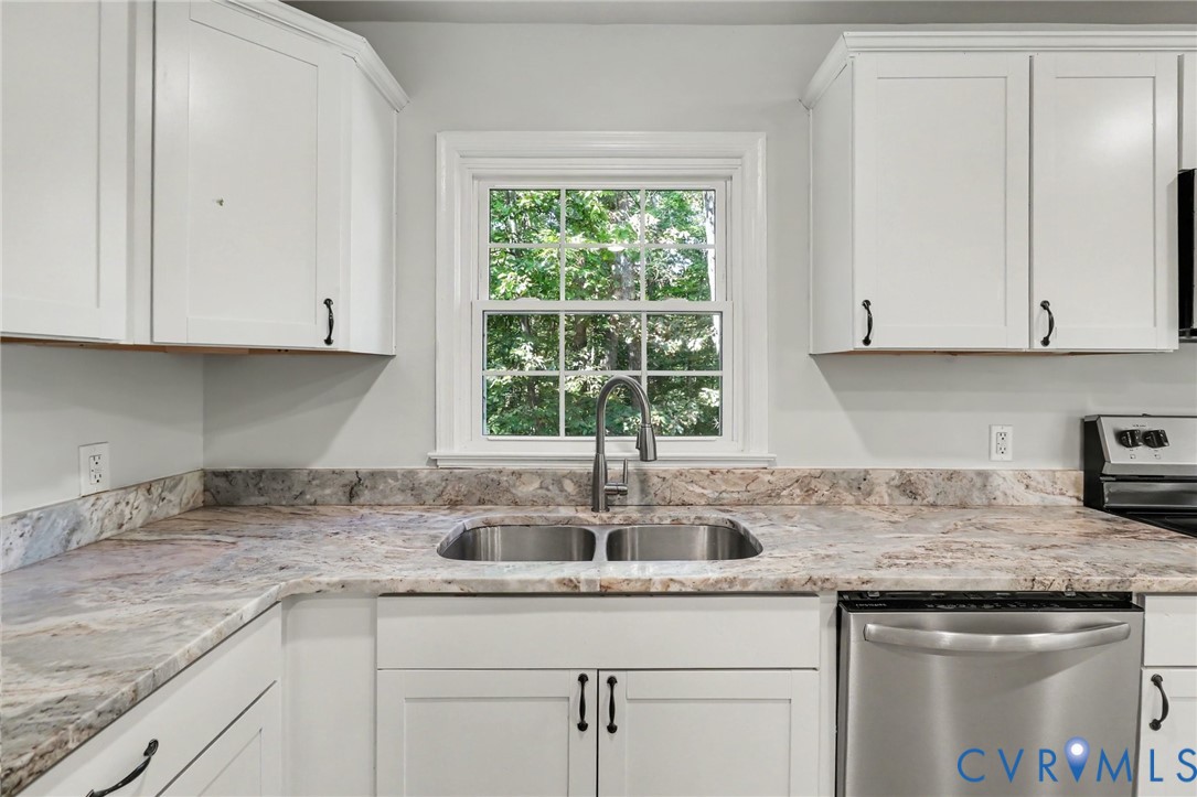 White cabinetry featuring Shaker-style doors, stone-surface countertops with integrated backsplash, stainless steel double-basin undermount sink, gooseneck faucet, and stainless steel dishwasher