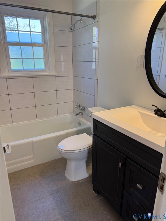 Bathroom featuring a white vanity cabinet with a contrasting countertop, integrated sink, matte black faucet, and large-format tile flooring Bathroom featuring a white vanity cabinet with a contrasting countertop, integrated sink, matte black faucet, and large-format tile flooring