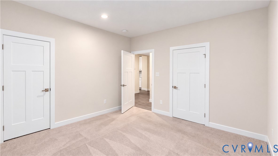 Neutral-toned room featuring three-panel interior doors, recessed lighting, and wall-to-wall carpeting