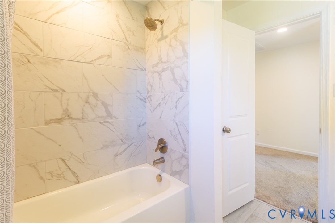 Full bath with tiled tub surround