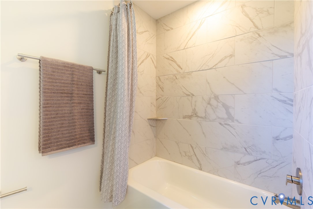 Full bath with tiled tub surround
