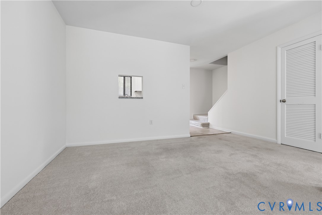 Neutral carpeting, inset wall opening, and louvered door