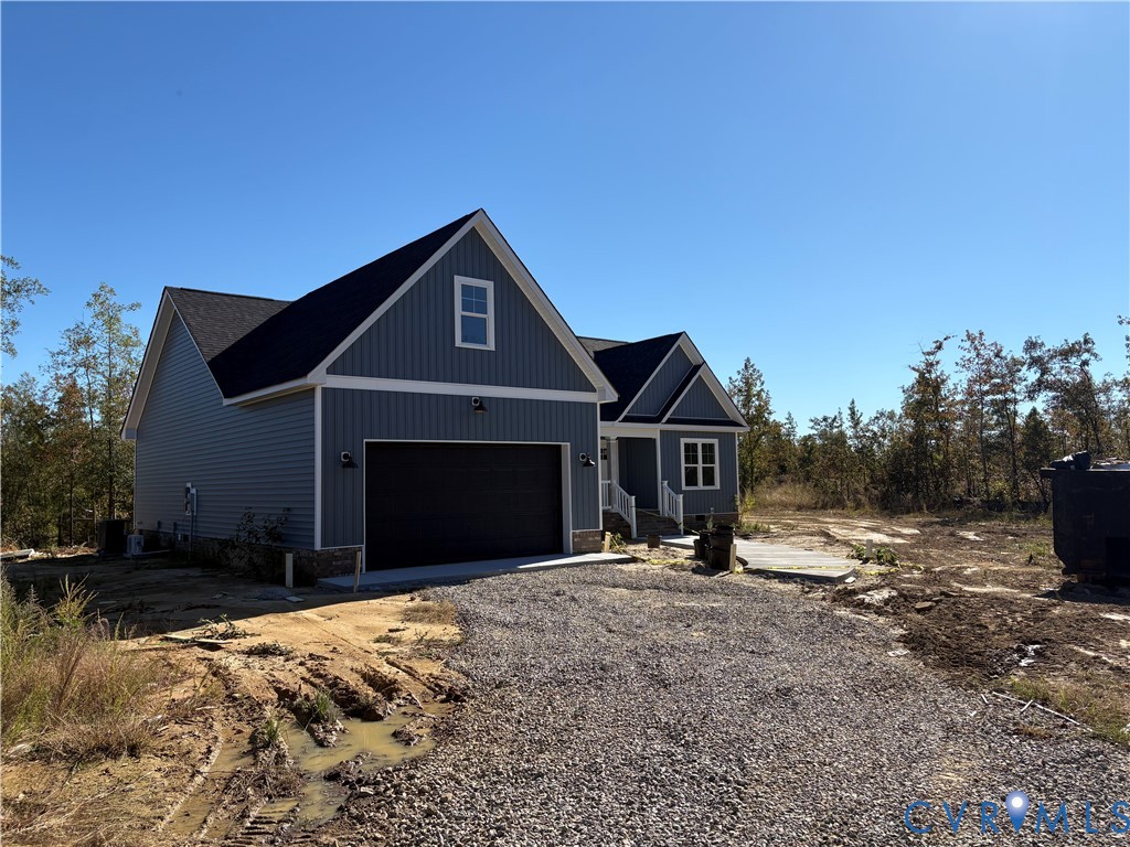 Single-story residence featuring board-and-batten siding, stone foundation trim, a dual-gable roofline, and an attached two-car garage Single-story residence featuring board-and-batten siding, stone foundation trim, a dual-gable roofline, and an attached two-car garage