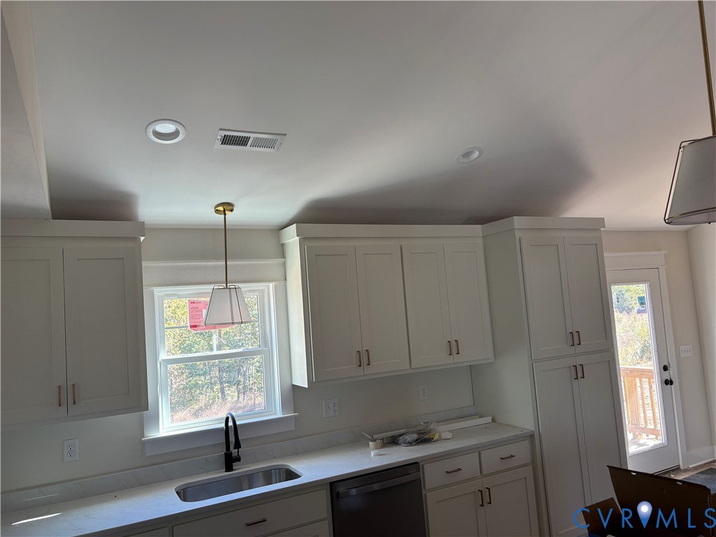 Kitchen featuring shaker-style cabinetry, matte black faucet with an undermount sink, stone-surface countertops, pendant lighting, and recessed ceiling lighting Kitchen featuring shaker-style cabinetry, matte black faucet with an undermount sink, stone-surface countertops, pendant lighting, and recessed ceiling lighting