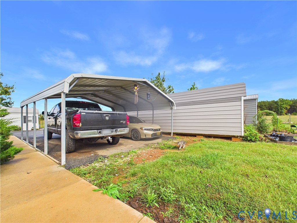Metal carport structure with a concrete pad and an additional metal-sided storage building