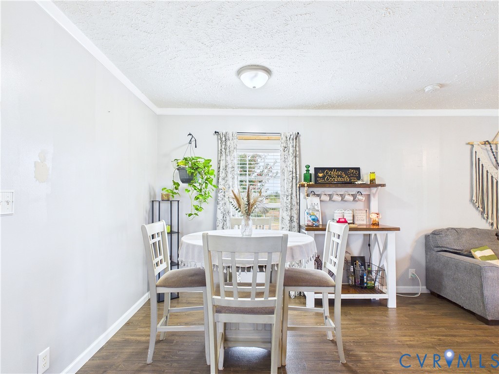Wood-finish flooring, central flush-mount ceiling lighting, and a single-pane window featuring horizontal blinds