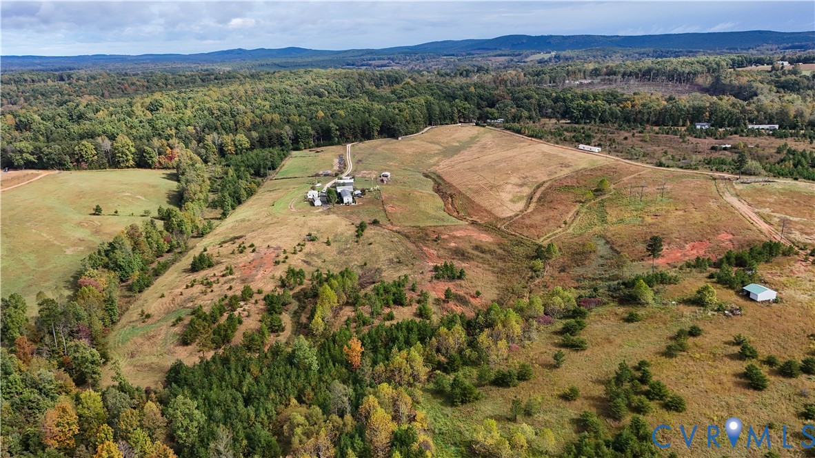 Expansive acreage featuring rolling topography, cleared pasture land, wooded boundaries, and distant mountain horizons