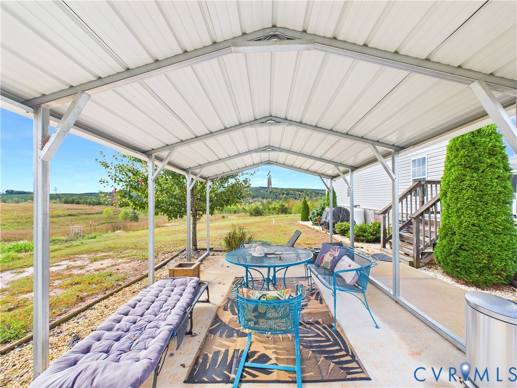 Covered patio featuring a metal roof structure, concrete flooring, and an expansive exterior outlook